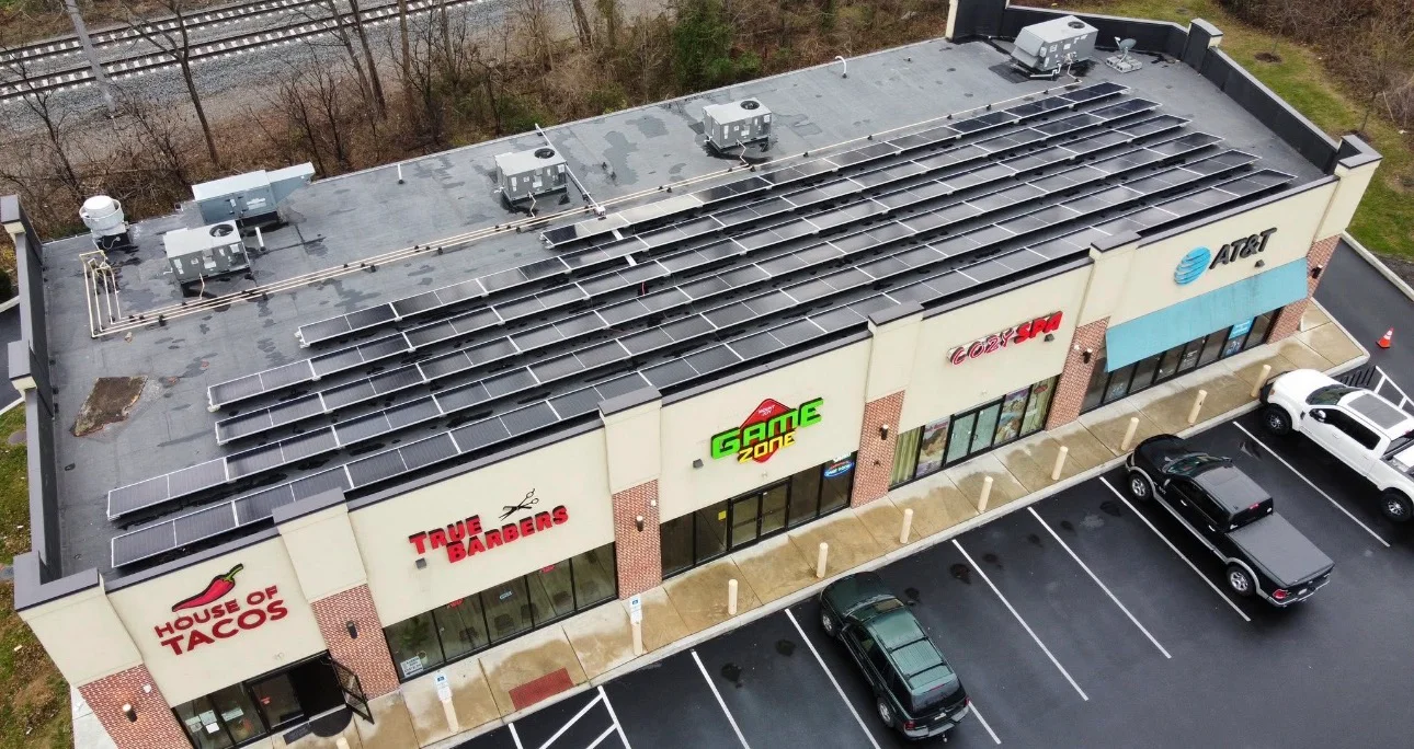 Aerial view of commercial building with extensive rooftop solar panel array installation