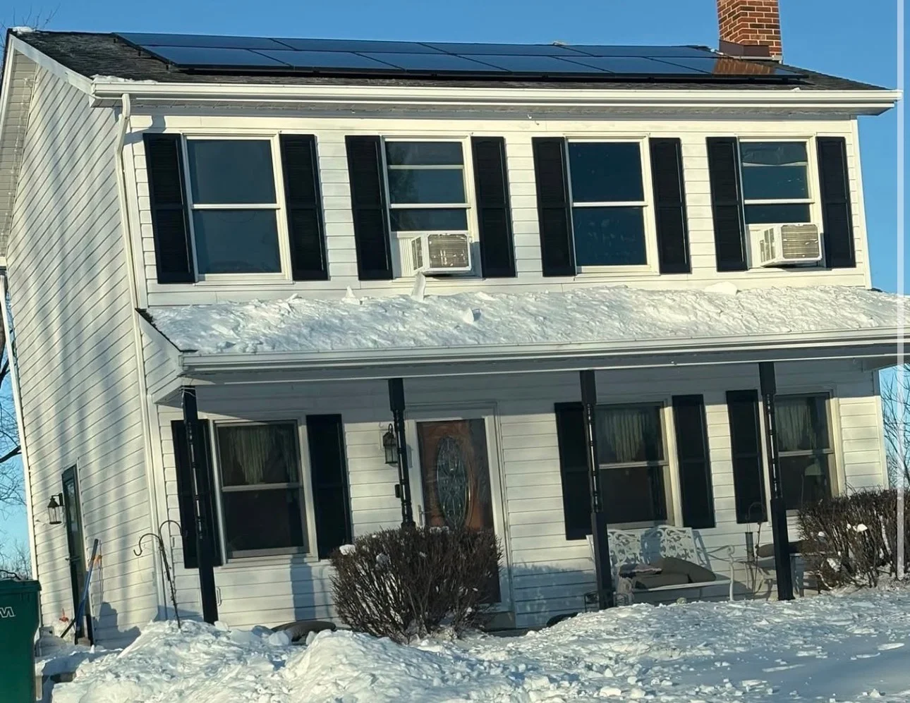 Solar panels installed on residential home roof in winter with snow coverage